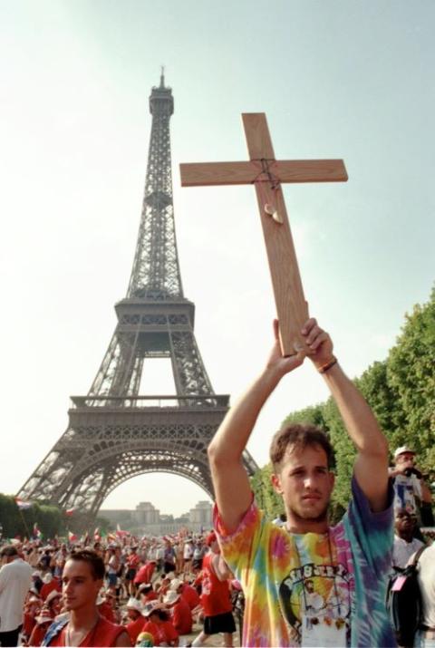 A World Youth Day pilgrim displays a cross near the Eiffel Tower during the 1997 gathering of Catholic young people in Paris. 