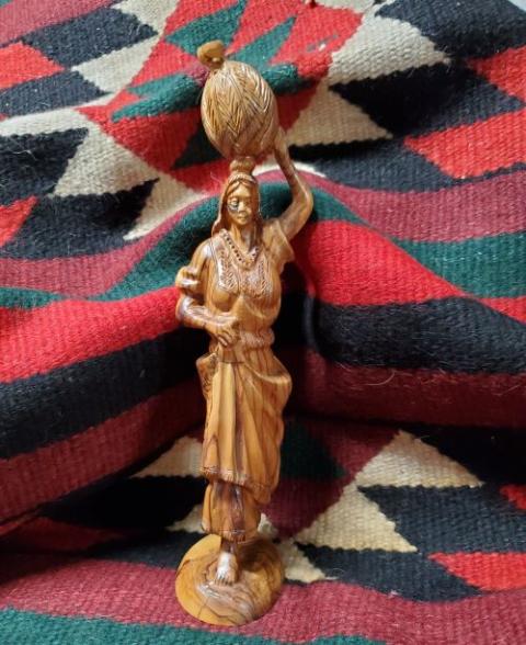 Olive wood statue of the Samaritan woman on a cloth