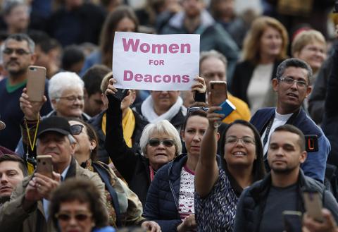 A woman holds a sign in support of women deacons as Pope Francis leads his general audience at the Vatican Nov. 6, 2019. (CNS/Paul Haring)
