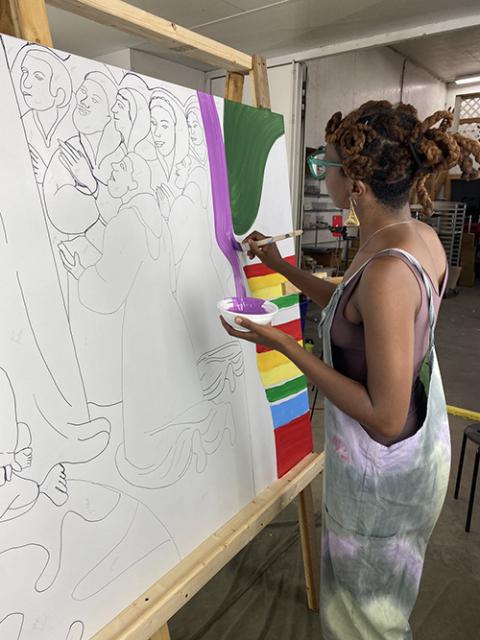 Raphaella Brice takes part in painting the Waterbury Area Anti-Racism Coalition community mural of her digital art "Madonna's Earth" in Waterbury, Vermont. (Courtesy of raphdraws.com)