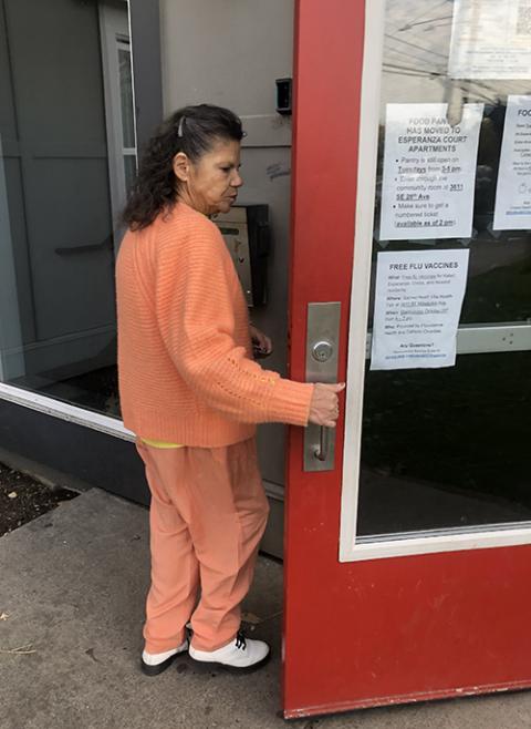 Sharon Browning opens the front door to Kateri Park apartments in Southeast Portland. The affordable housing complex includes 20 units of permanent supportive housing. (NCR photo/Katie Collins Scott)