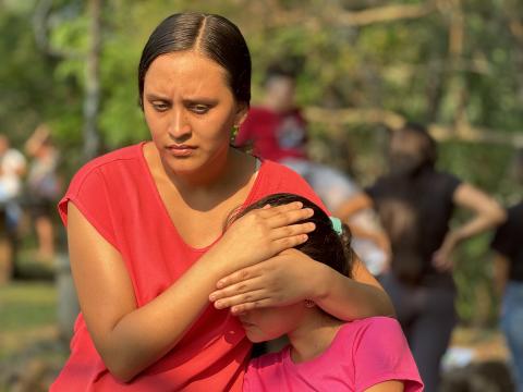 In Arcatao, El Salvador, two young people listen on April 27 to part of the story of May 14, 1980, when armed forces ambushed and then killed more than 600 peasants and their children at the Sumpul River. (GSR photo/Rhina Guidos)