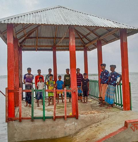Fishermen and their children take shelter in a lightning protection shelter at Panchauniya Haor in the Baniachang subdistrict June 13. (Courtesy of Caritas Bangladesh)