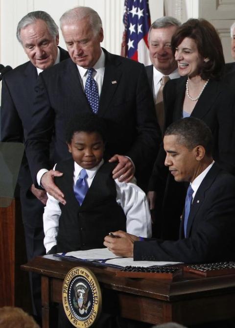 El entonces vicepresidente Joe Biden observa cómo el presidente estadounidense Barack Obama firma la legislación sobre atención médica.
