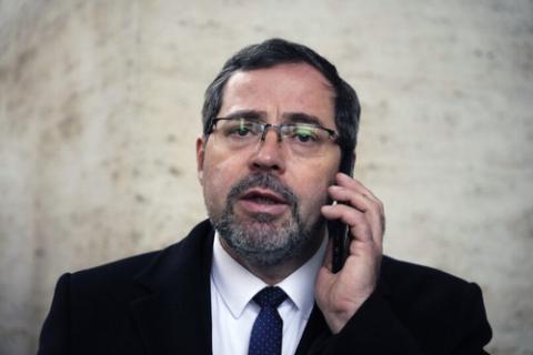 Andrii Yurash, Ukrainian Ambassador to the Holy See, Vatican City, 2022. Yurash wears black suit and talks on cell phone.