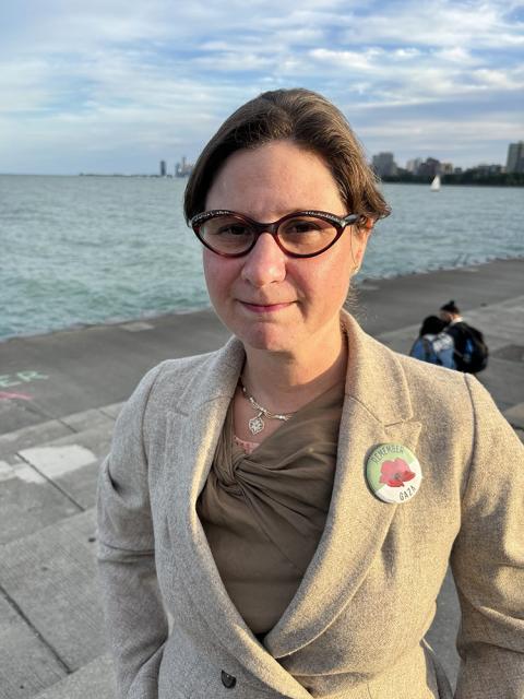 Annie Sommer Kaufman, Chicago, Aug. 20, 2024. Kaufman stands at edge of lake, wearing a pin reading "Remember Gaza."