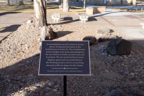 Sex abuse memorial plaque, Santa Fe, N.M. Plaque is shown in small garden area.