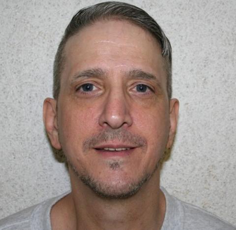 Richard Glossip, 2016. Head shot of Glossip against gray wall, smiling.