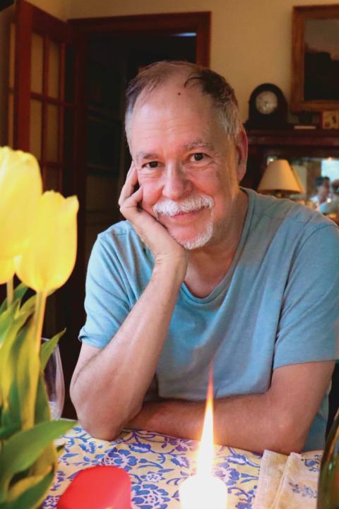 Gregory Maguire portrait Gregory Macguire, author of Wicked: The Life and Times of the Wicked Witch of the West, is pictured from the chest-up, seated and subtly smiling with his arms on a table.