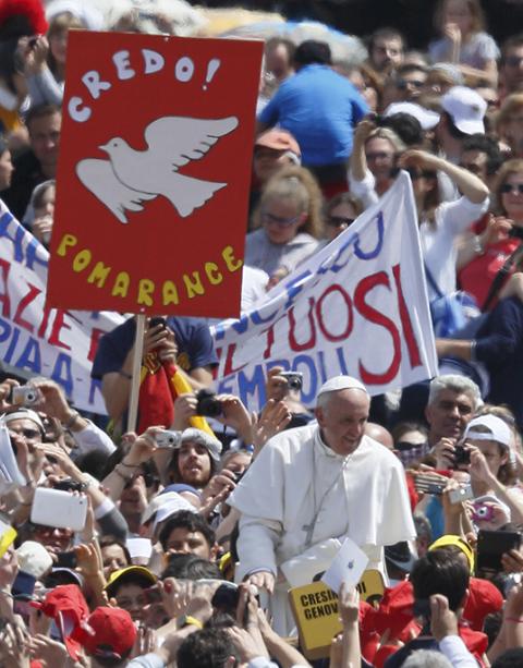 A sign with a dove symbolizing the Holy Spirit is seen as Pope Francis greets the crowd after celebrating a Mass in St. Peter's Square at the Vatican in this April 28, 2013, file photo. (CNS/Paul Haring)