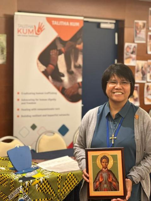 Sr. Abby Avelina holds a photo of St. Josephine Bakhita. 