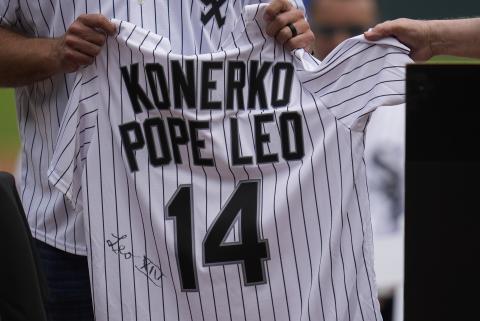 Cardinal Blase Cupich, right, presents former Chicago White Sox player Paul Konerko with a jersey 