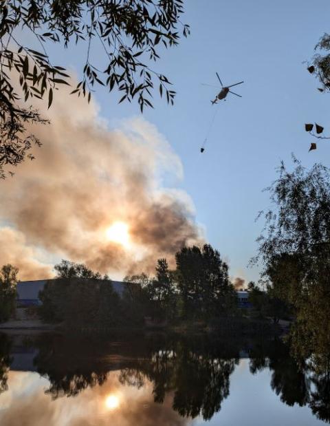 A fire-fighting helicopter collects water to control a fire after Russian missile and drone strikes in Kyiv, Aug. 28. (OSV News/Reuters)