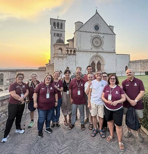 Volunteers with Terra Laudato Si' pose outside the Basilica of St. Francis in August 2026 following a gathering of young Franciscans in Assisi, Italy. (Courtesy of Terra Laudato Si')
