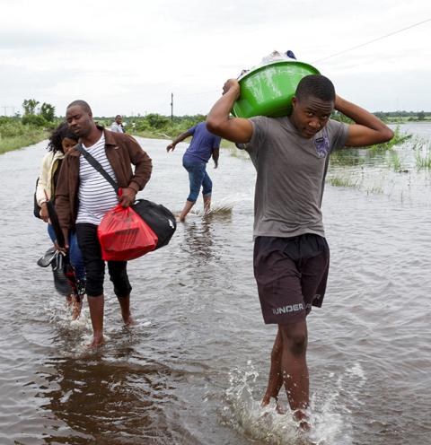 Displaced people carry their belongings through floodwaters in Maputo, Mozambique, Jan. 18, 2026, after weeks of heavy rainfall. (OSV News/Reuters/Amilton Neves)