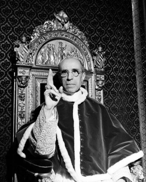 Pope Pius XII raises his right hand in a papal blessing at the Vatican in September 1945. The Vatican has long defended Pius XII against criticism that he remained silent as the Holocaust unfolded. (AP)