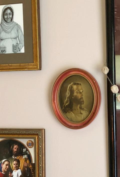 A 1950s-era framed print of Warner Sallman’s “Head of Christ” is seen among other religious art on the wall of a Catholic home. (Diane Ortiz)