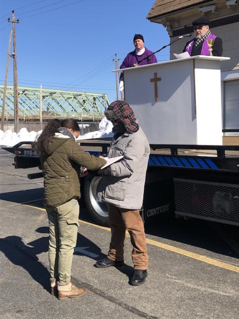 A catechumens signs the Rite of Election at an outdoor Mass of  St. Patrick Parish in Lawrence, Massachusetts (Courtesy of St. Patrick Parish)