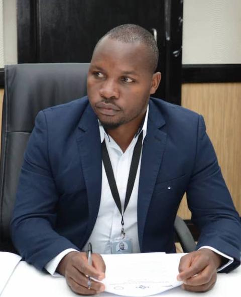 Boniface Chibwana, coordinator for the Catholic Commission for Justice and Peace of Malawi's bishop's conference sitting at desk