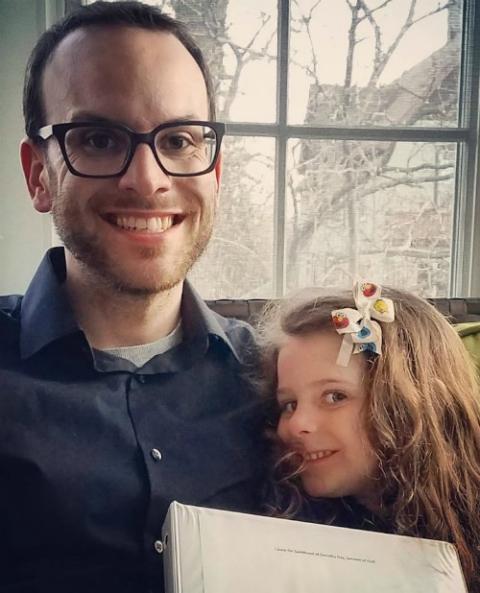 Mark Piper and his daughter, Rachel Day, hold a binder containing copies of Dorothy Day's diaries that he transcribed. (Provided photo)