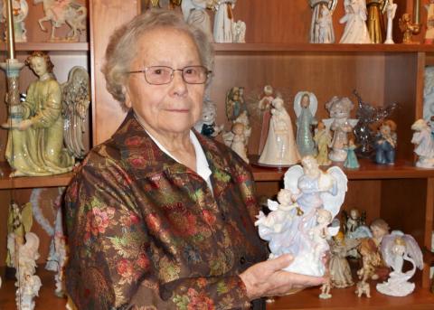 Charity Sr. Helen Scasny holds a harp-playing angel at the chapel of Light of Hearts Villa, a senior care center in Bedford, Ohio. Christmas angels come out of storage to take a prominent spot in the collection during Advent. (CNS/Jerri Donohue)