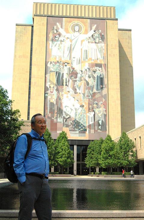 Phil Sakimoto stands in front of the "Word of Life" mural on the Hesburgh Library at the University of Notre Dame (William E. O'Dell)