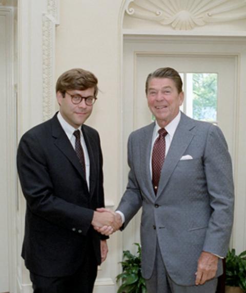 William Barr shakes hands with President Ronald Reagan during a National Security Council meeting in the Oval Office Aug. 9, 1983. (Ronald Reagan Presidential Library)