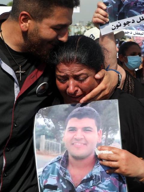 A relative of a victim of last year's Beirut port blast carries his picture during a march marking the one-year anniversary Aug. 4. (CNS photo/Mohamed Azakir, Reuters)