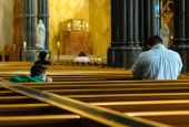 A child watches his father pray inside the Cathedral of Sts. Peter and Paul in Providence, Rhode Island. (CNS/Bob Mullen)