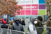 People wearing protective gear wait in line to be tested for the coronavirus (COVID-19) outside Elmhurst Hospital Center in the Queens borough of New York City March 25. (CNS/Reuters/Stefan Jeremiah)