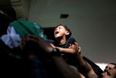 The brother of Palestinian Ahmed al-Shenbari, who was killed during Israeli-Palestinian violence, cries during his funeral in the Gaza Strip May 11. (CNS/Reuters/Mohammed Salem)