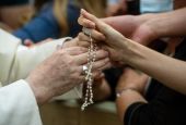 Pope Francis greets a person with a rosary during his general audience in the Vatican's Paul VI hall Aug. 18, 2021. The pope continued his series of talks on St. Paul's Letter to the Galatians. The pope said the law was meant to teach the path toward true