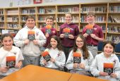 Seventh graders at Our Lady of Lourdes School in Slidell, La., pose for a photo with the book "A Long Walk to Water," a nonfiction novel by Linda Sue Park. (CNS/Clarion Herald/Beth Donze)