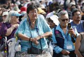 A woman holds a rosary as people wait for the start of Pope Francis' celebration of Mass at Commonwealth Stadium July 26 in Edmonton, Alberta. (CNS/Paul Haring)