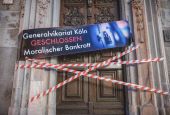 A banner with the inscription "Generalvikariat Köln — Geschlossen — Moralischer Bankrott" ("Vicar General's office Cologne CLOSED. Moral bankruptcy") and barrier tape are pictured stretched over the archdiocesan office in Cologne, Germany, Aug. 15.