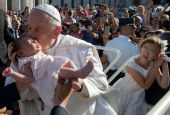Pope Francis kisses a baby before attending Mass in St. Peter's Square during the World Meeting of Families at the Vatican June 25. The event usually takes place every three years, but it was not held last year because of the COVID-19 pandemic. 