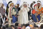 Pope Francis dons a headdress during a visit with Indigenous peoples at Maskwaci, the former Ermineskin Residential School, Monday, July 25, 2022, in Maskwacis, Alberta. (AP Photo/Eric Gay)