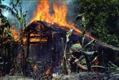 Pfc. Raymond Rumpa of St. Paul, Minnesota, in Mỹ Tho, Vietnam, a Viet Cong base camp burning April 5, 1968 (National Archives/U.S. Army/Dennis Kurpius)