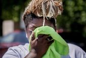Nicole Brown wipes sweat from her face while setting up her beverage stand near the National Mall July 22, during a heat wave in Washington, D.C. (AP/Nathan Howard)