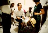 Dr. Paul Farmer sits with a young leukemia patient, Marta Cassmand, in Cange, Haiti, in January 2004. Marta's father, Sanoit Valceus (foreground), had cut a tendon in his hand and was asking Farmer for advice. (Newscom/PSG/St. Petersburg Times)