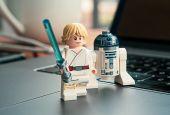 Lego "Star Wars" minifigures Luke Skywalker and R2-D2 are pictured. In "Star Wars," Luke receives a lightsaber at Obi-Wan Kenobi's hut on the planet Tatooine. Eric Clayton reflects on building a Lego set of the hut with his daughter. (Unsplash/Studbee)