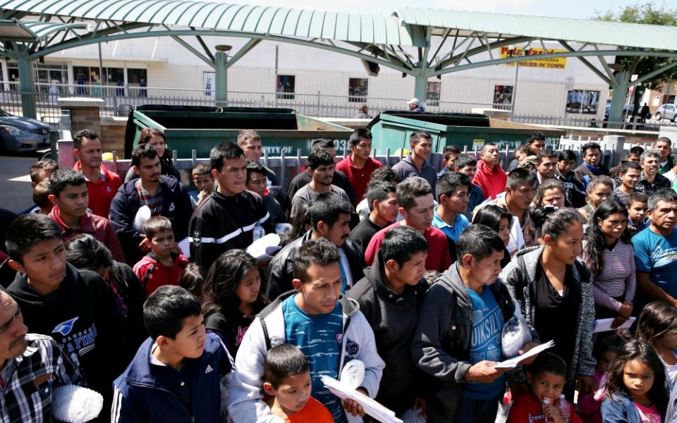 Immigrants just released from detention via a U.S. immigration policy known as "catch and release" stand at a bus station April 11 before being taken to the Catholic Charities relief center in McAllen, Texas. (CNS/Reuters/Loren Elliott)