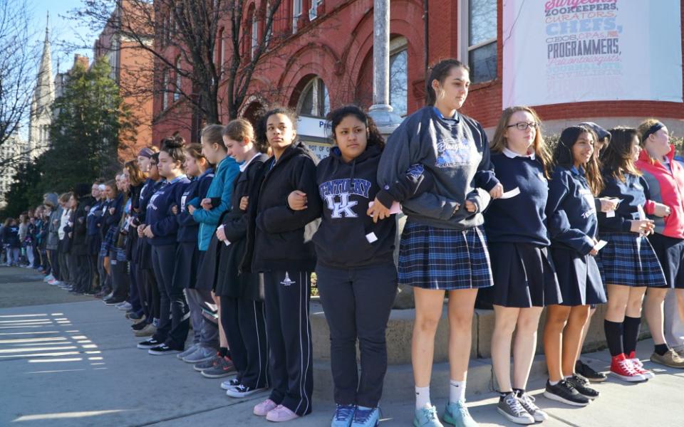 Presentation Academy students stand arm in arm on the sidewalk in downtown Louisville, Kentucky, after walking out of class March 14, 2018, to call attention to gun violence. (CNS/The Record/Marnie McAllister)