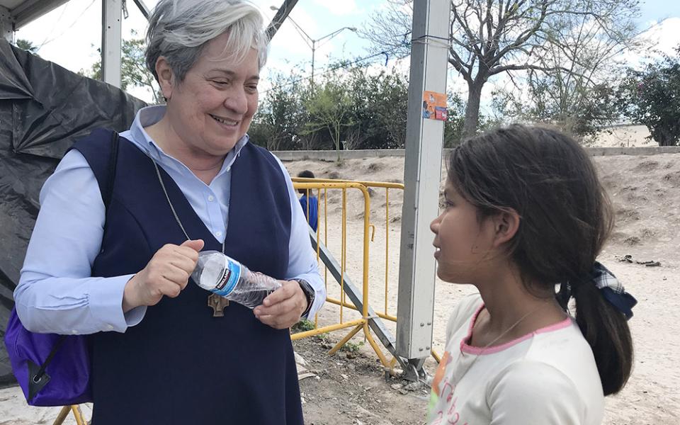 Sr. Norma Pimentel, director of Catholic Charities of the Rio Grande Valley in Texas, speaks with a young resident of a tent camp housing some 2,500 asylum-seekers in Matamoros, Mexico, Feb. 29, 2020. (CNS/David Agren)