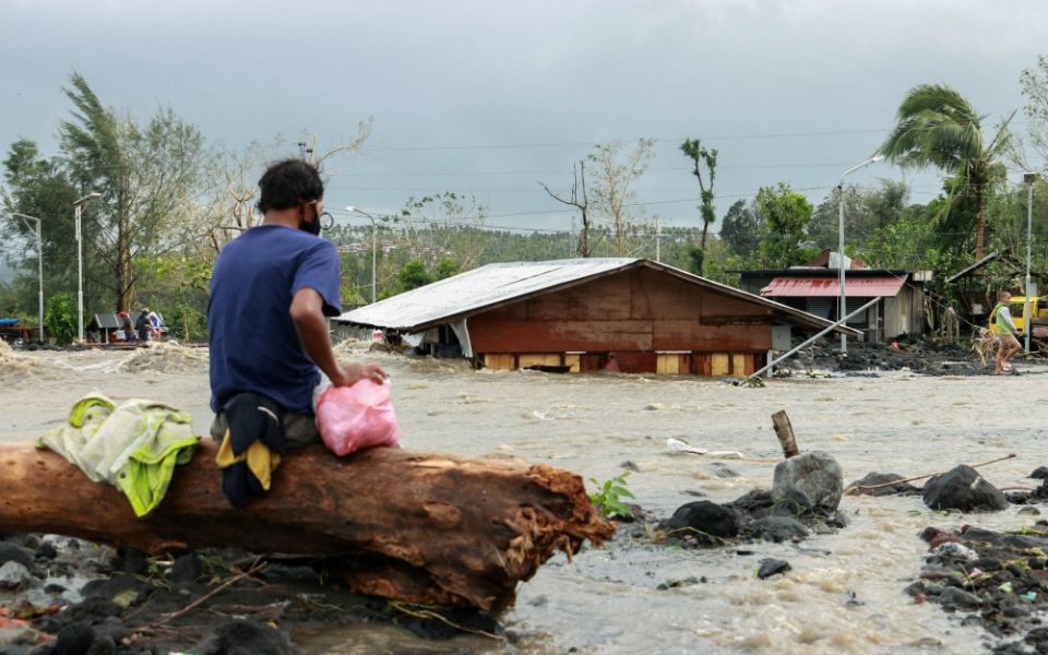 A man looks at his house buried under the pile of rubble and sand in Daraga, Philippines, Nov. 1, following flash floods brought by Super Typhoon Goni, also known as Rolly. The storm left at least 10 people dead and three missing. (CNS/Reuters)