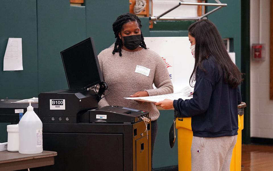 A poll worker looks on as a voter casts her ballot on Election Day Nov. 3, 2020, at William S. Mount Elementary School in Stony Brook, New York. (CNS/Gregory A. Shemitz)