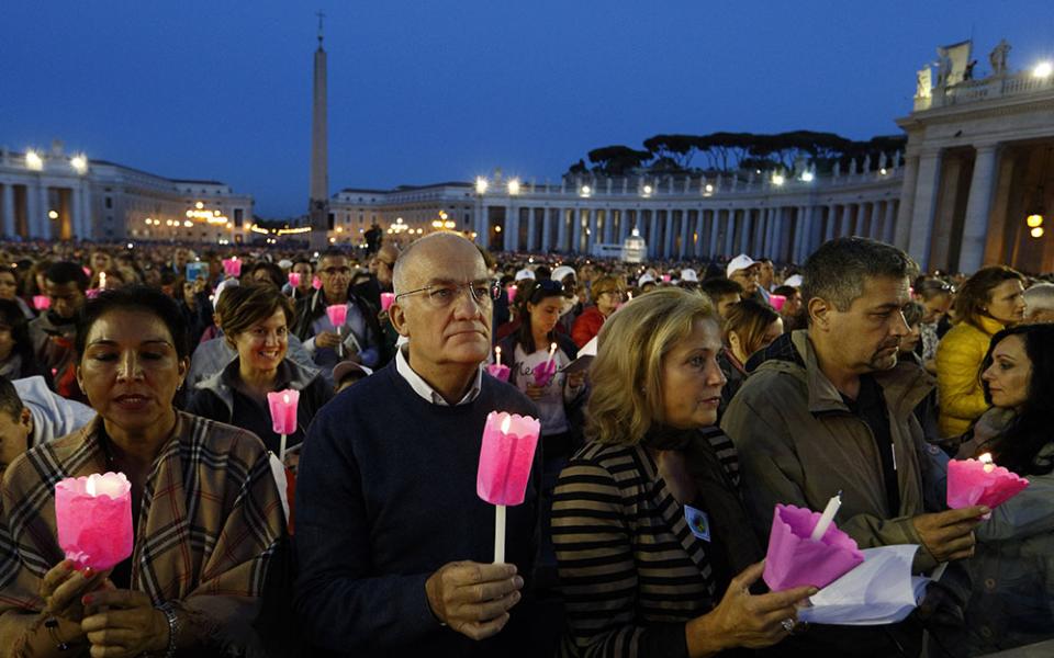People hold candles during a prayer vigil for the Synod of Bishops on the family attended by Pope Francis in St. Peter's Square at the Vatican Oct. 3, 2015.