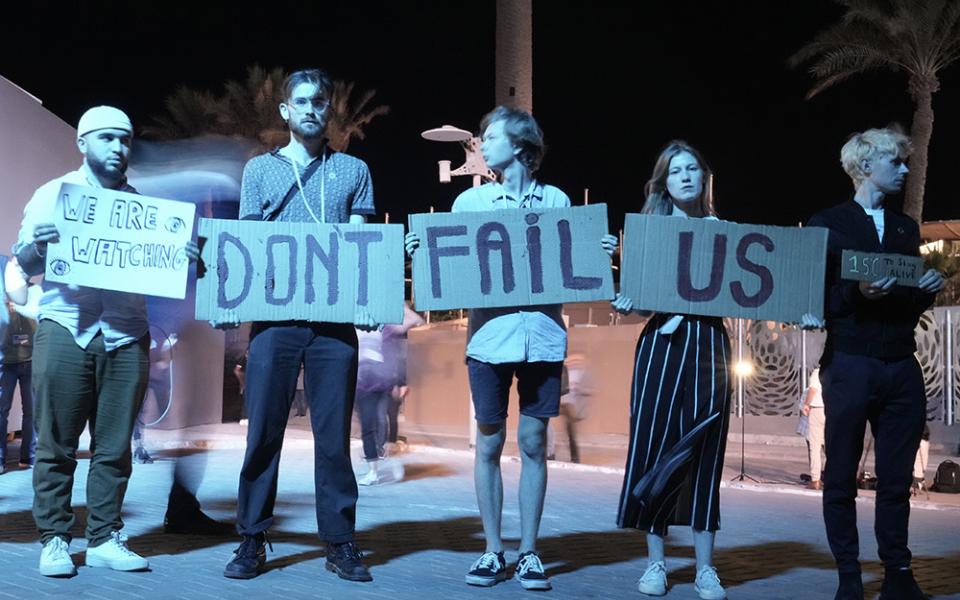 Activists hold signs at the COP27 U.N. Climate Summit on Nov. 19 in Sharm el-Sheikh, Egypt. (AP/Nariman El-Mofty)