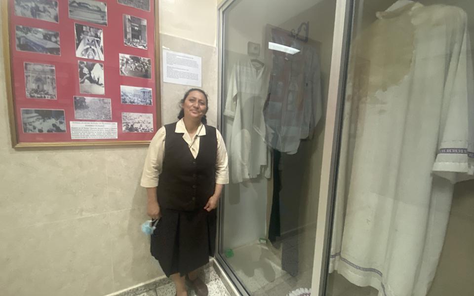 Sr. Ruby Lemus Salguero stands next to a case that holds the bloodstained relics of St. Oscar Romero March 24, on the grounds of the Divine Providence Hospital in San Salvador, El Salvador. Among the relics is the habit of a nun, one of the Missionary Carmelites of St. Teresa, who ran to Romero's side after he was fatally shot and whose dress absorbed some of the martyr’s blood. (GSR photo/Rhina Guidos)