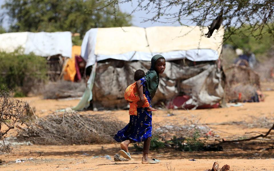 A young Somali refugee fleeing drought carries her sibling as they walk in the new arrivals area of the Hagadera refugee camp in Dadaab, near the Kenya-Somalia border, in Garissa County, Kenya, Jan. 17. (OSV News/Reuters/Thomas Mukoya)